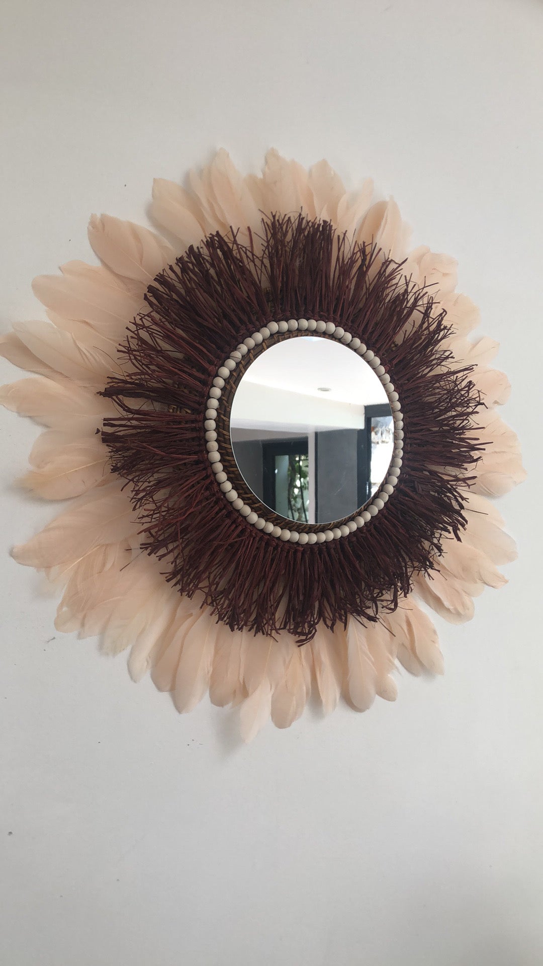 Large wine-coloured raffia mirror and champagne-coloured feathers