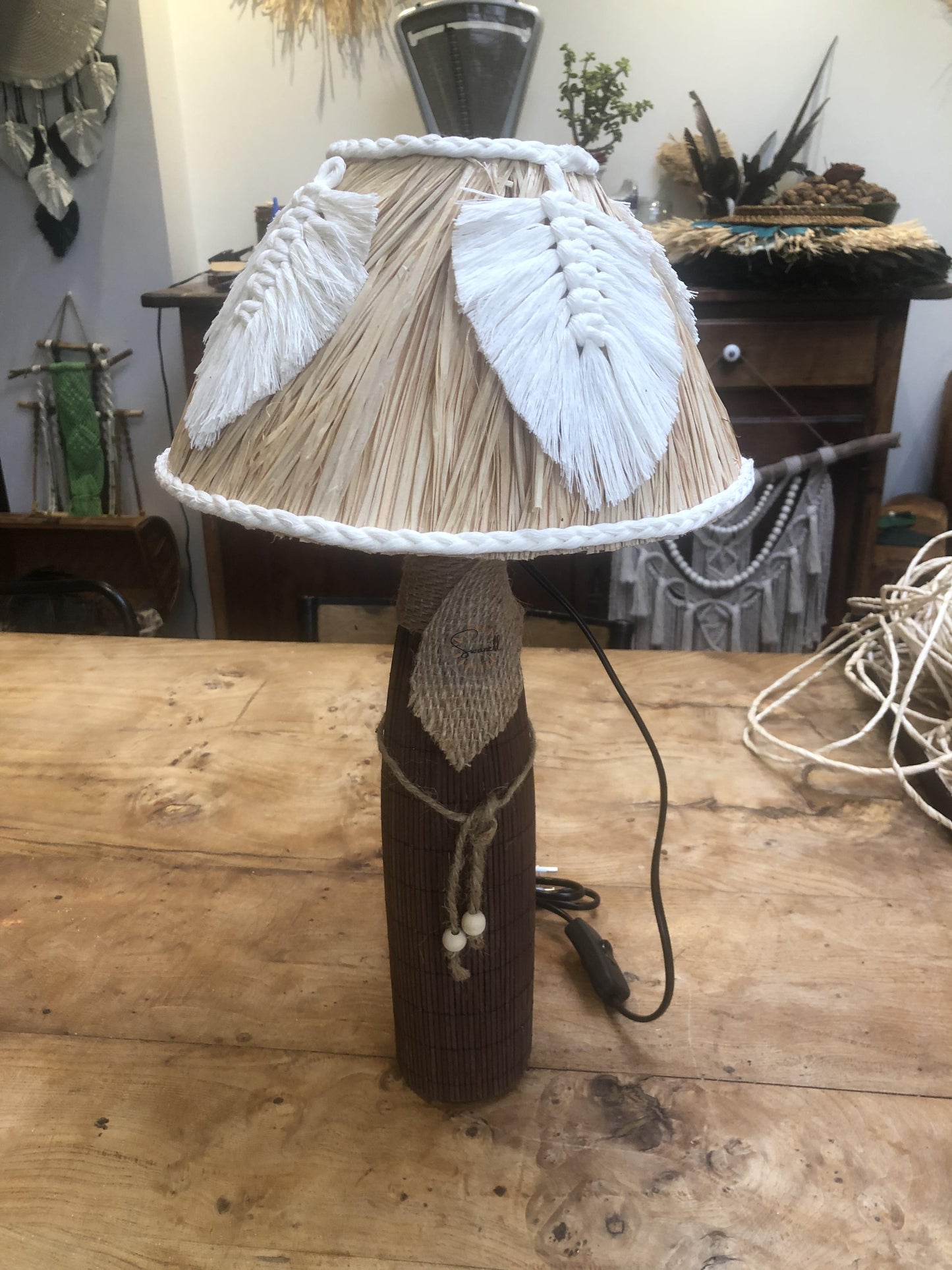 Lampe sur pied marron avec feuilles en macramé écrues