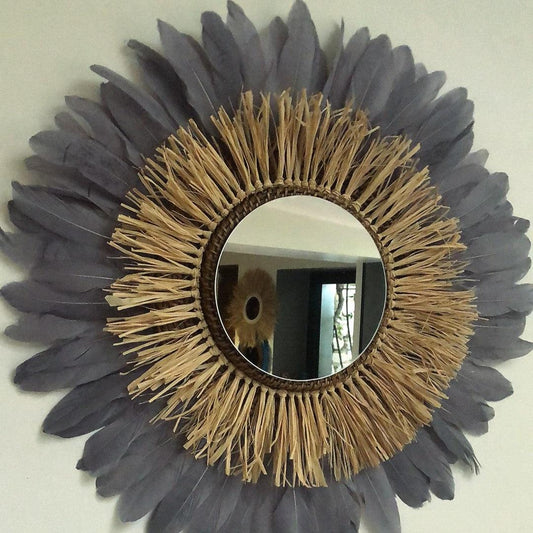 Large round raffia mirror and gray feathers