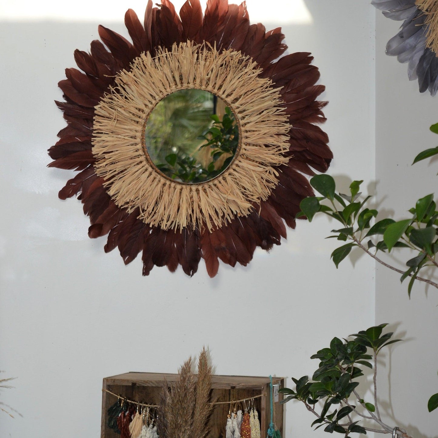 Large round mirror with chocolate feathers and natural raffia