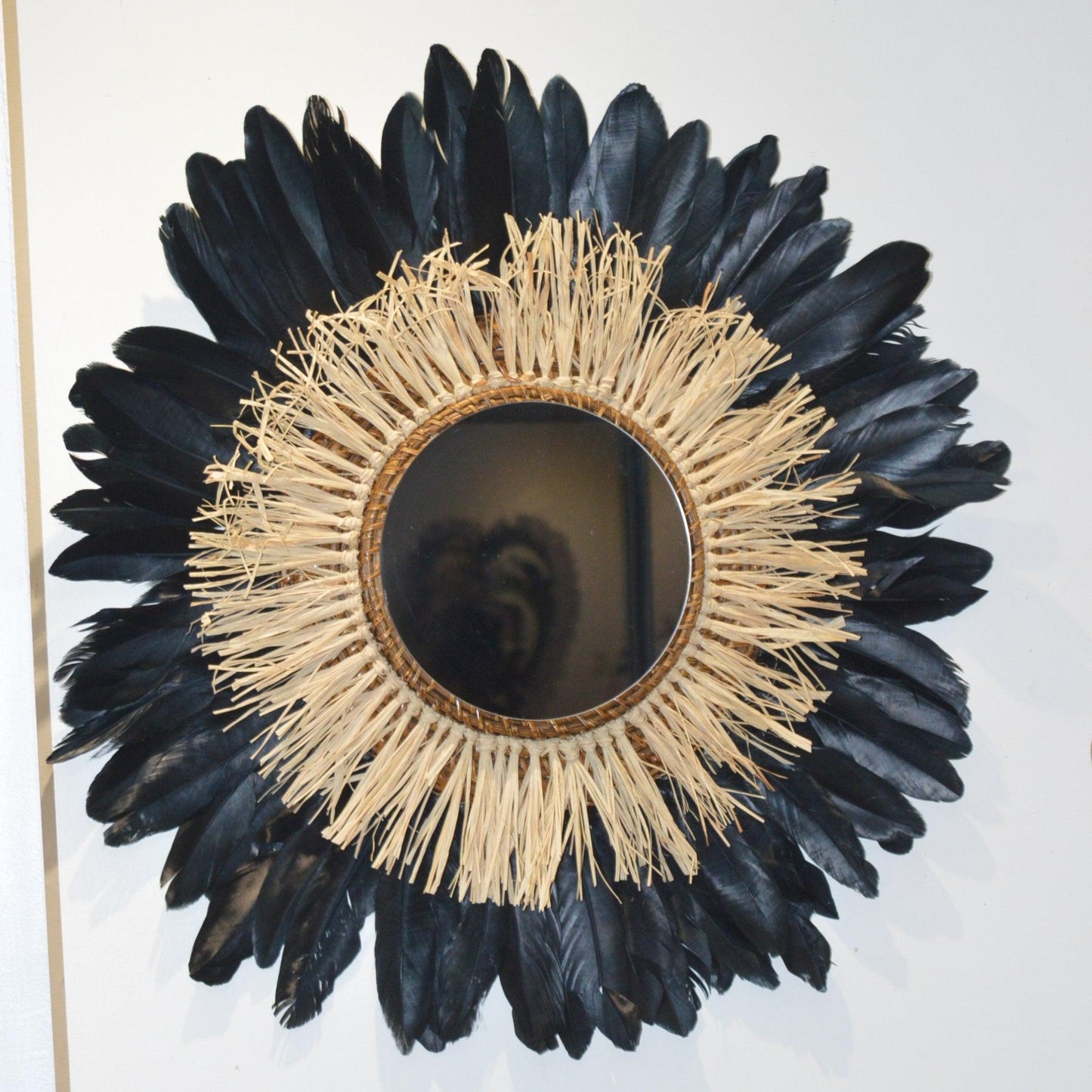 Large round raffia mirror and black feathers