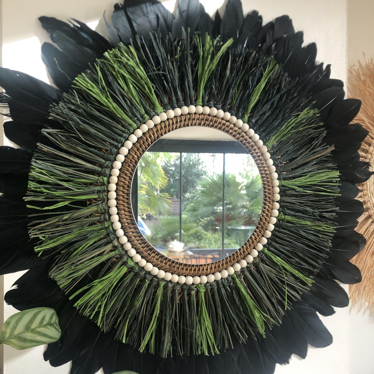 Woody-scented mirror, green raffia and feathers