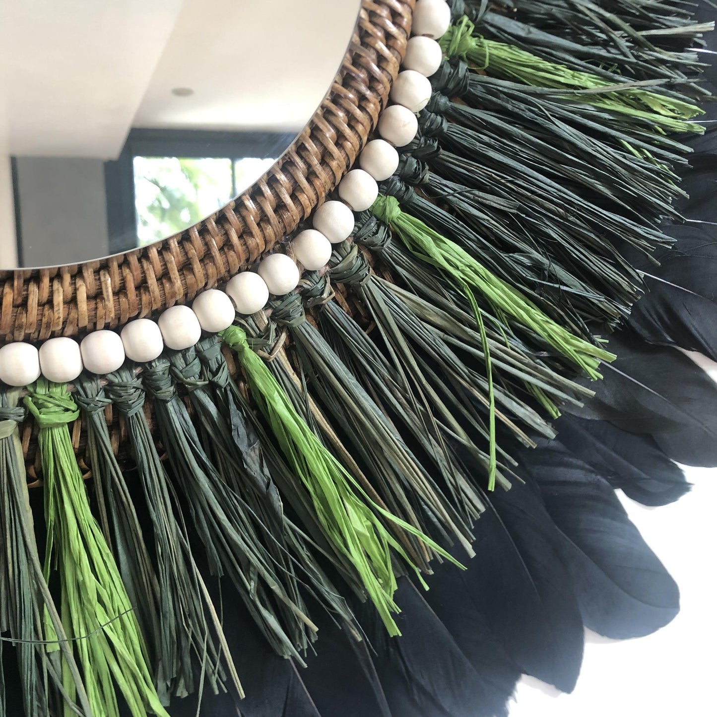 Woody-scented mirror, green raffia and feathers