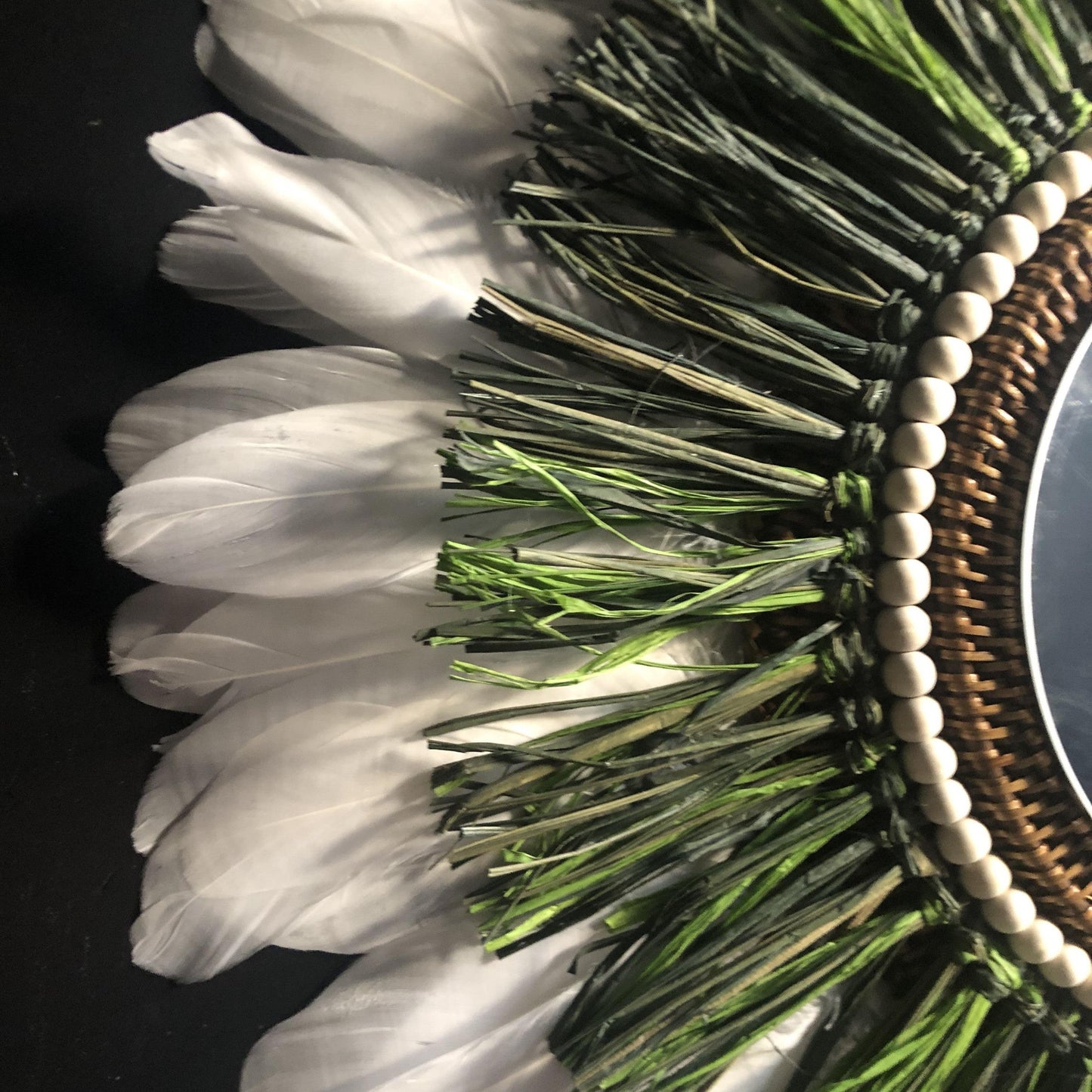 Woody-scented mirror, green raffia and feathers