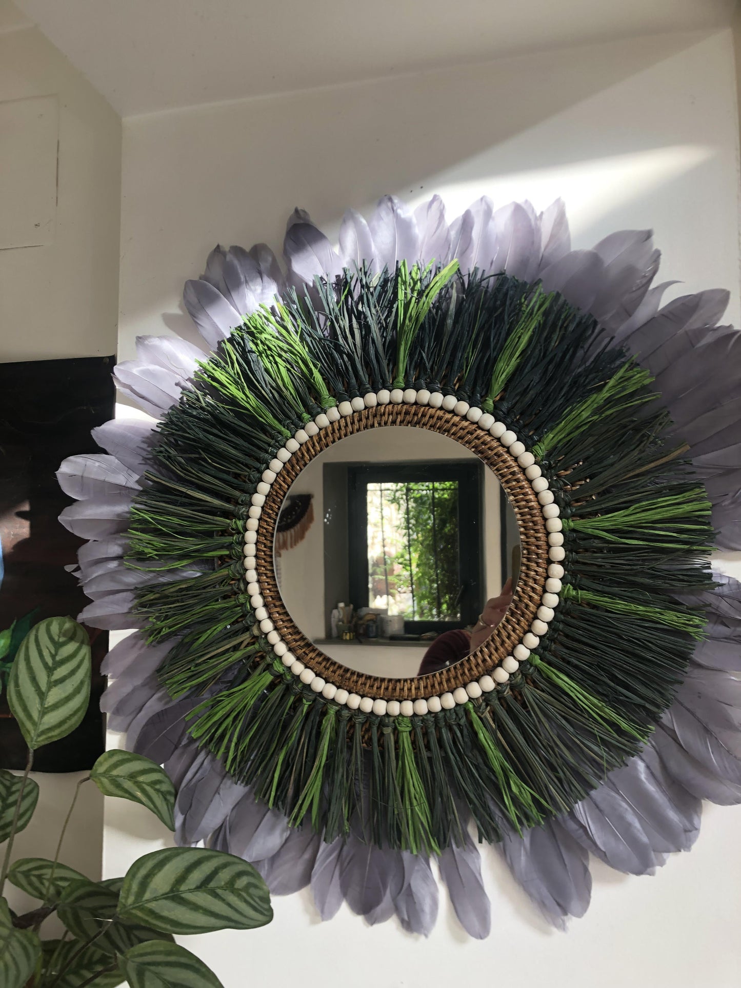 Woody-scented mirror, green raffia and feathers