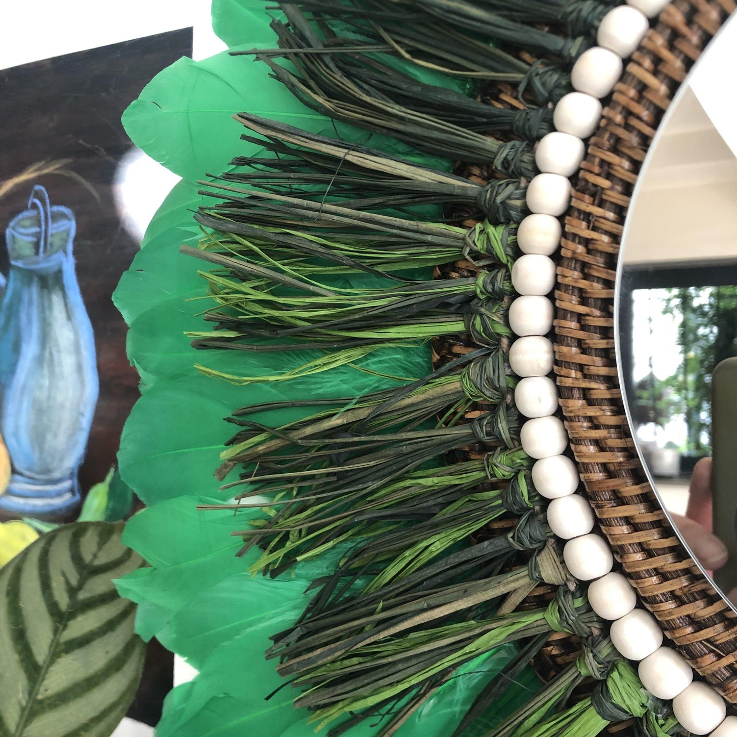 Woody-scented mirror, green raffia and feathers