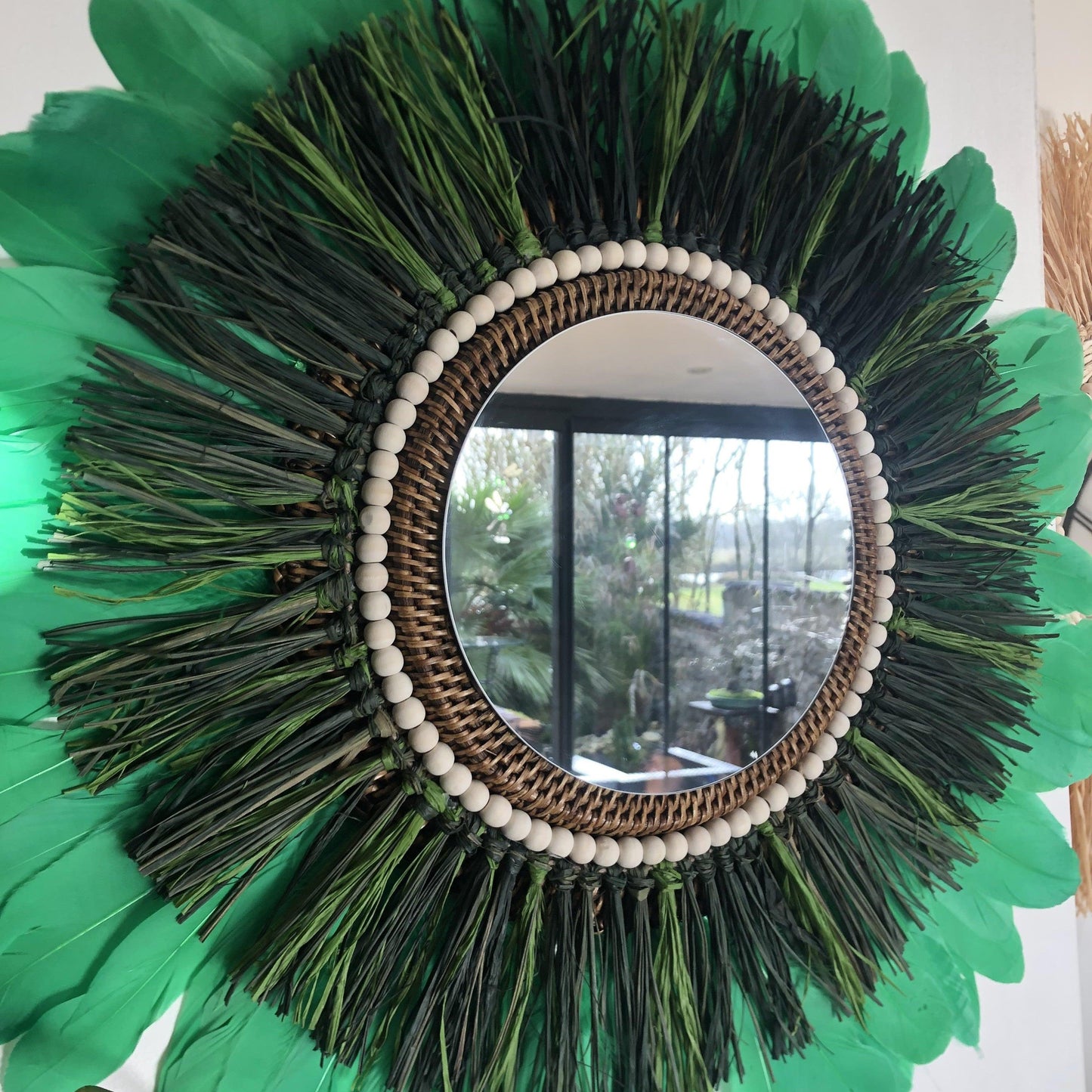 Woody-scented mirror, green raffia and feathers